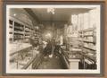 The Wilbur Bolton Mercantile Co. of Antelope - 1914 - Dry Goods Dept. Behind counter: Clem Greenwald and Gatch Bolton. In aisle: Scotty McRae, Vivian Bolton. Note both electric light and gas service