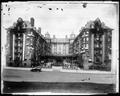 Front view, Portland Hotel. Auto parked on 6th St. in foreground. Building decorated with flags and bunting. Copy of earlier photo.