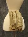 Bustle of four vertical wire coil springs covered in cotton with attached waistband