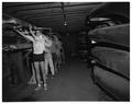 Members of the Beaver crew team moving a shell in the training barn