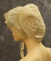 Cap of white organdy with floral vine embroidery in a satin stitch with open-work