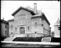 Exterior of gymnasium building at Washington High School, Portland. Building on low hill above foreground sidewalk.