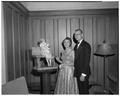 Participants in the president's reception for faculty posing at the Memorial Union next to a statue of a mother with child.