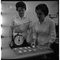 Students working with a scale in a Home Economics research lab, February 1964