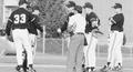 Coach Pat Casey with baseball players and umpire