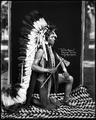 Tats-homi, Cayuse indian, in costume, including war bonnet, and with war implements