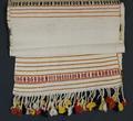 Loin Cloth of hand-woven natural white cotton with added weft figured bands at center and ends in red, yellow, and black