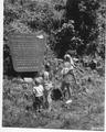 Woman and children reading signage about 1962 storm