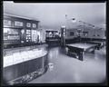 Capitol Billiard Parlor. Interior view, showing tables in background, windows behind cigar counter in left foreground.