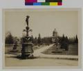 State Capitol Building at end of walkway through park. Monument in foreground. (recto)