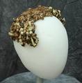 Headband-style hat of brown and natural colored straw constructed into a design of flowers and berries