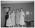 Four women posing at a tea party, circa 1955