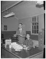 Journalism professor Sam Bailey and secretary Pat Eccles folding weeklies, January 1955