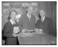 Members of an alumni reunion committee look at historic photographs.