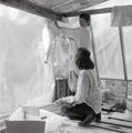 Two women hanging plastic sheeting