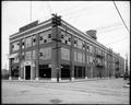 Ford Motor Co. building at 11th and Division, Portland. Auto parked in background. Water tank on top of building.