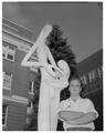 Wayne Taysom posing with a sculpture of his creation