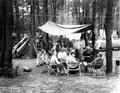 Campers around fire under awning
