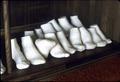Row of plaster molds of feet on display in front case of Mr. S's shop