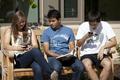 Three students hanging out on bench outside of Global Scholars Hall