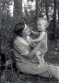 Woman sitting on ground holding a baby