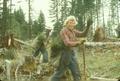 Firefighter walking up hill away from fire with drip torch in hand