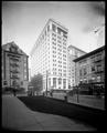 Northwestern National Bank building, under construction at 6th and Morrison, Portland. Scaffolding on building, Post Office grounds in foreground.