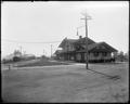 Station at Vancouver, WA. Men and baggage wagons on platform in front of building, SP&S approaching from background bridge.