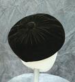 Beret style hat of dark brown velvet with covered button at center crown
