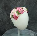 Capulet hat of pale and dark pink synthetic peonies with green leaves on a molded head form that fits on the crown of the head