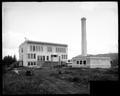 Jonesmore School No. 22, Portland, under construction. Building materials on site. Power plant in foreground.