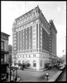 Hotel Benson at Broadway and Oak, Portland. Corner of other building in foreground. Autos on street.