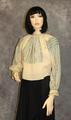 Blouse of ivory cotton gauze with heavily embroidered cross-stitch bands in light blue yarn
