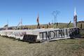 Concrete road barriers, flags, and signs used during the Dakota Access Pipeline protests