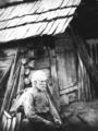 Elderly man [Nick Barton] in front of cabin