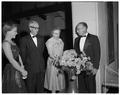 August and Mollie Strand examining a floral arrangement with two others