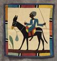 Wall Hanging of woven flax with colorful scene of a man riding on a donkey